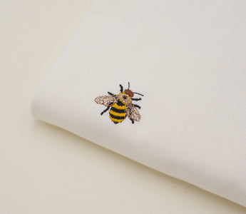 Ein besticktes Streetwear-T-Shirt mit einem detaillierten Design, das moderne und kreative Stickerei zeigt.