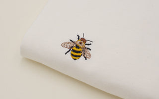 Ein besticktes Streetwear-T-Shirt mit einem detaillierten Design, das moderne und kreative Stickerei zeigt.