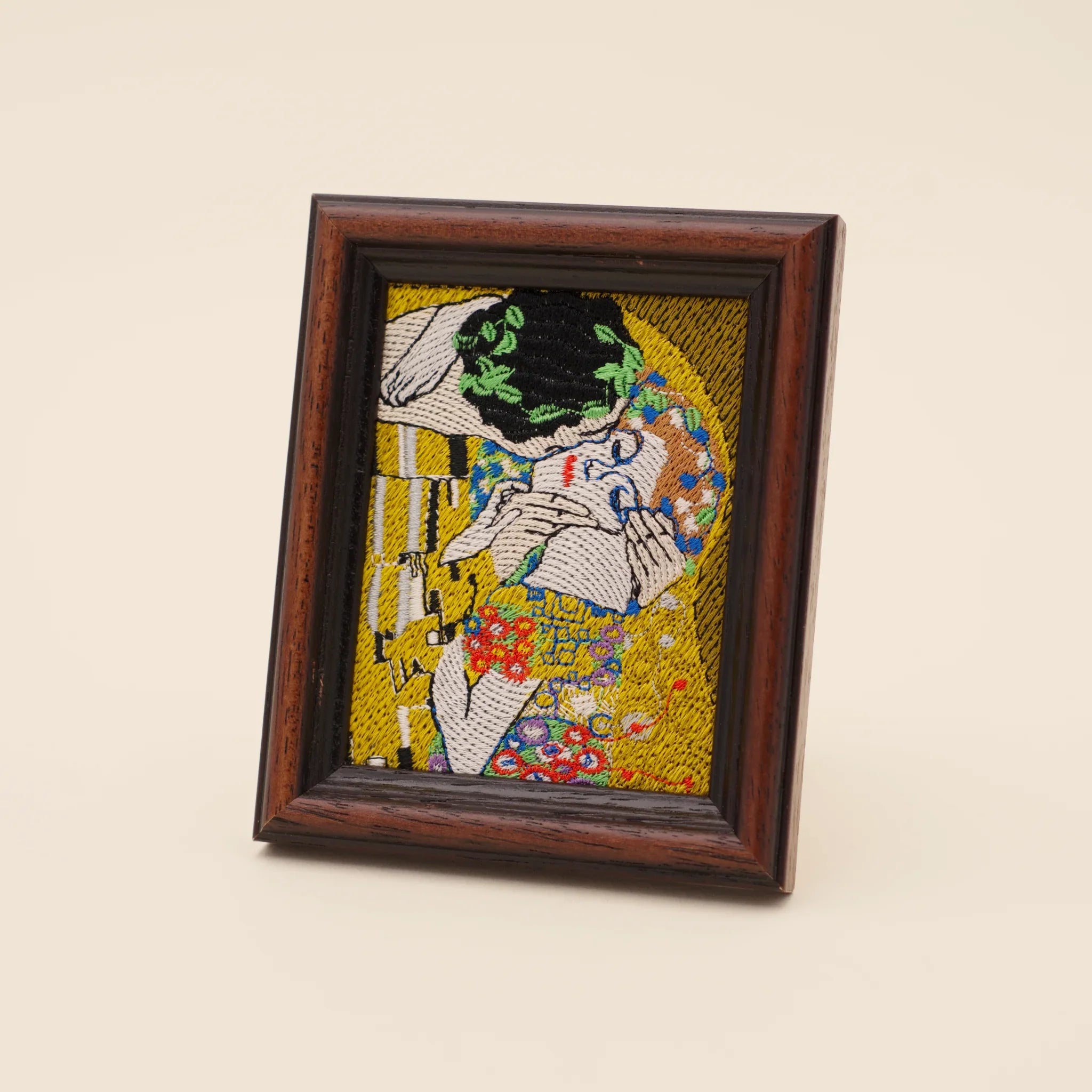 Embroidered detail of Klimt's The Kiss in a wooden frame