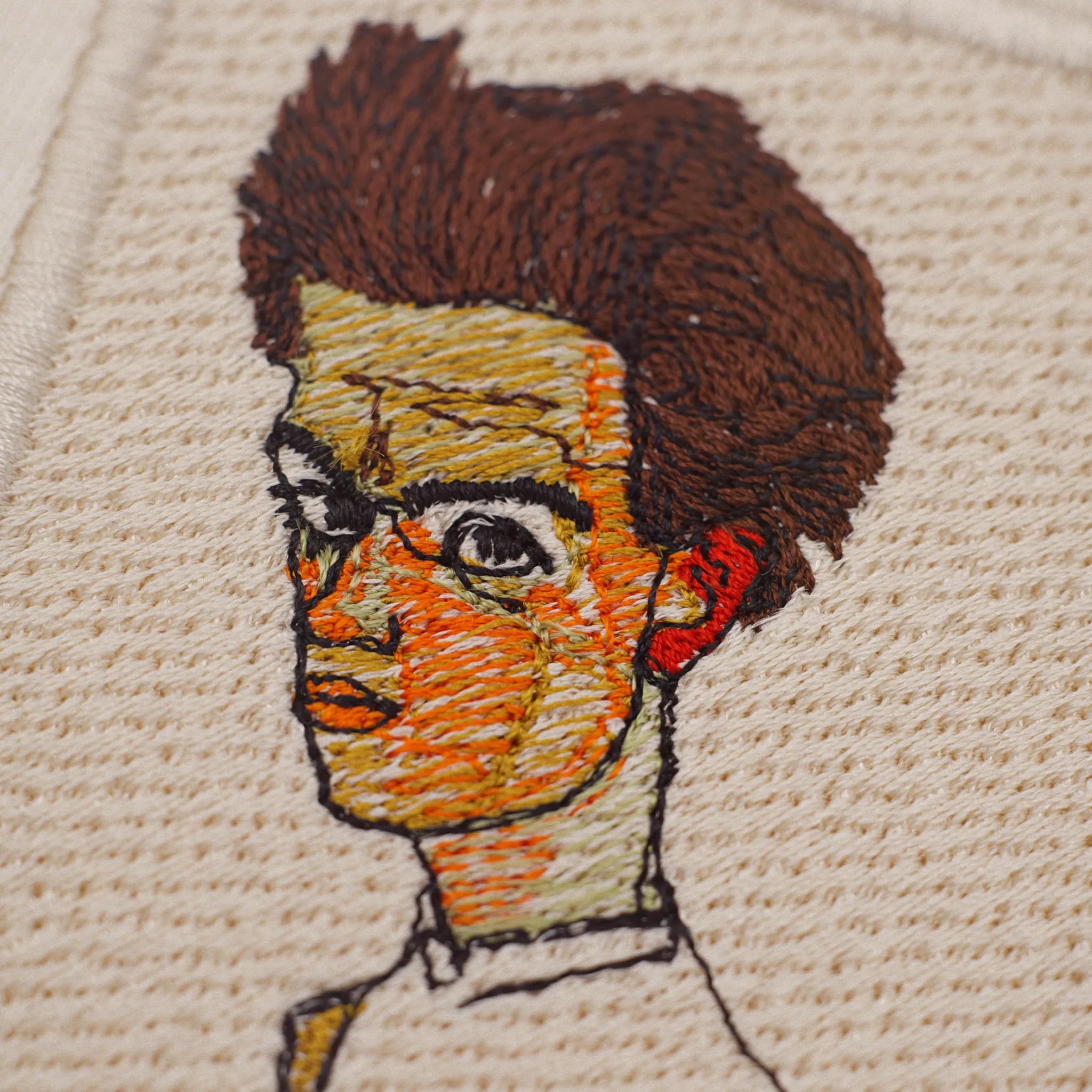 Close-up of machine embroidery: face and hair of the Schiele portrait in fine stitches