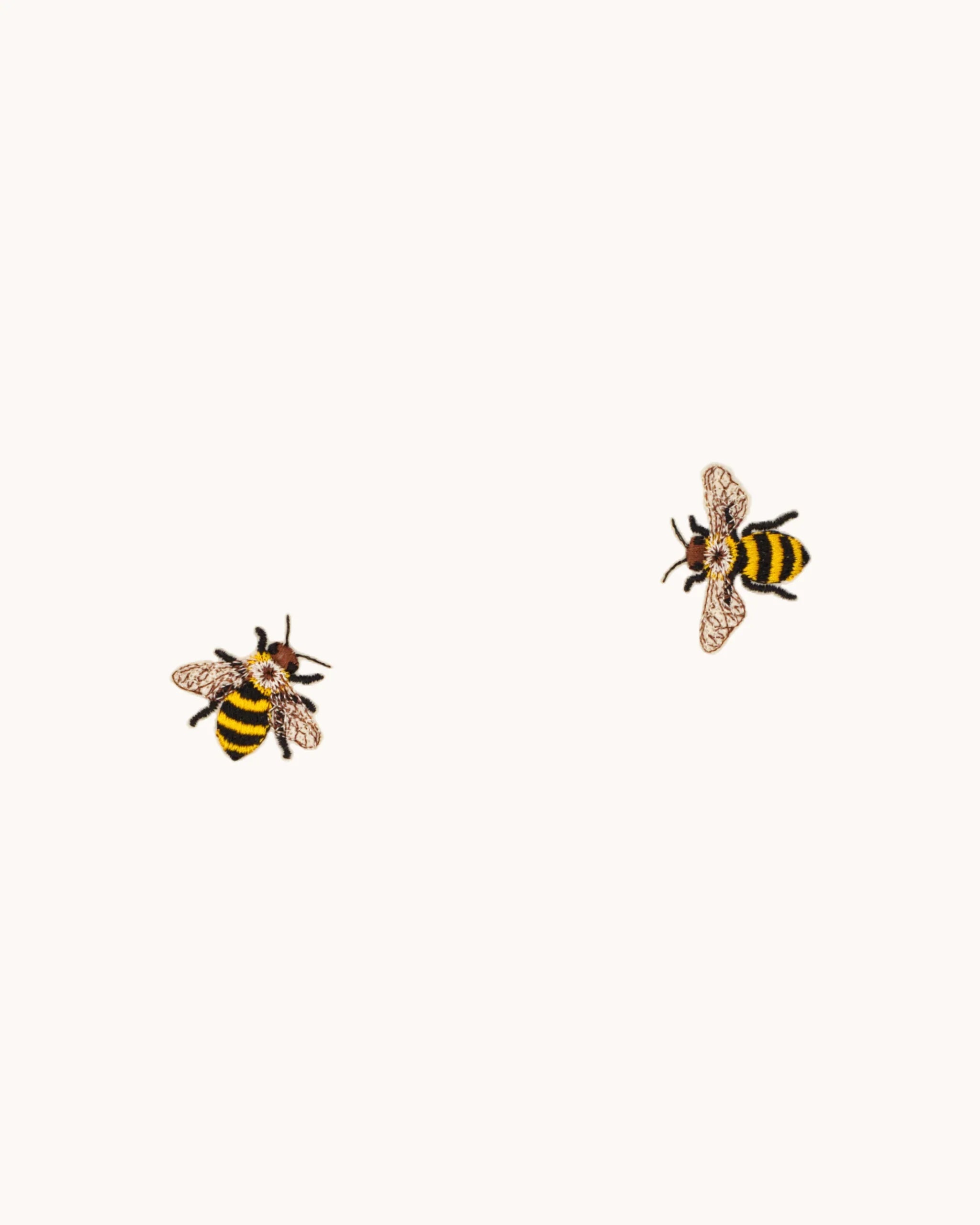 Two embroidered bees with fine wings and stripes